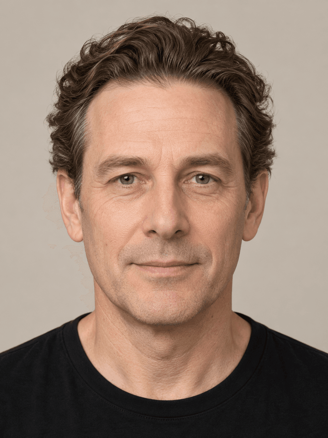 Man, front view, with fair skin and wavy brown hair brushed straight back.