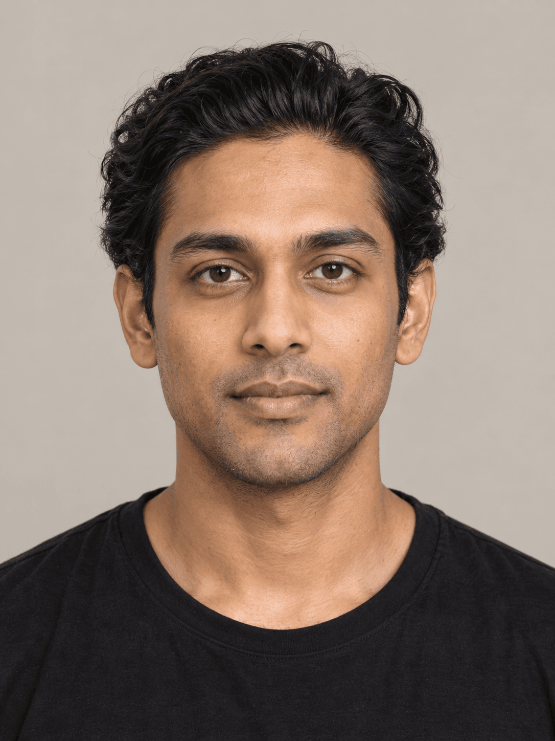 Man, front view, with medium brown skin and thick wavy black hair brushed straight back.