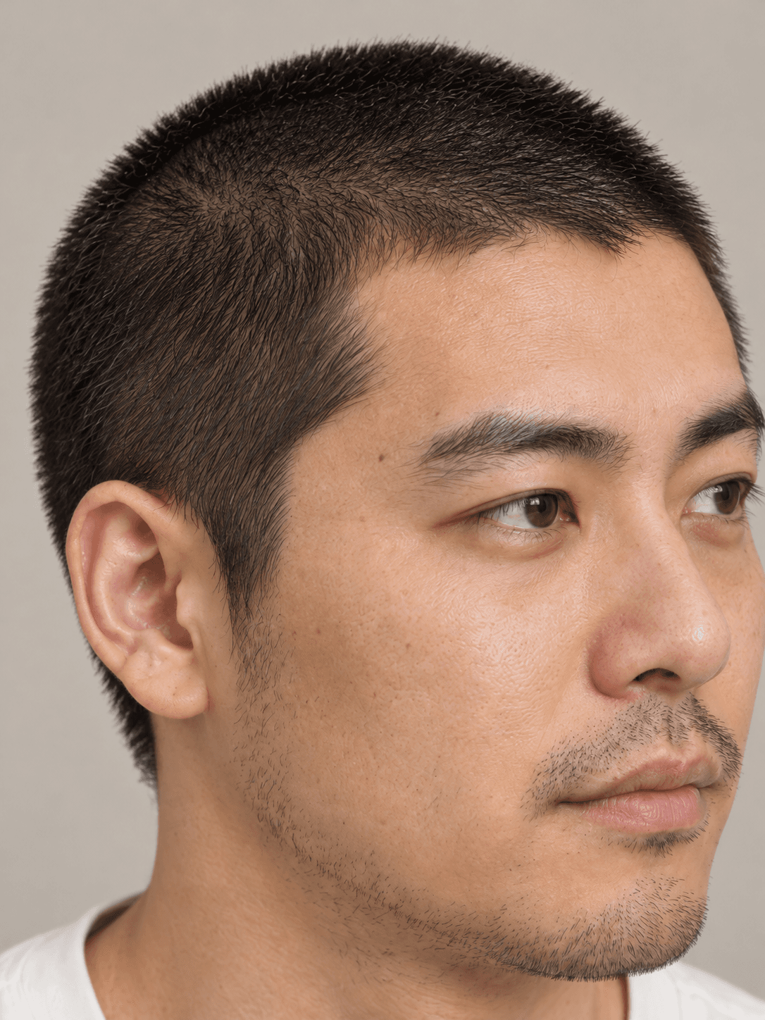 Buzz Cut on a man with straight black hair, close view of the even length at the side and the natural hairline