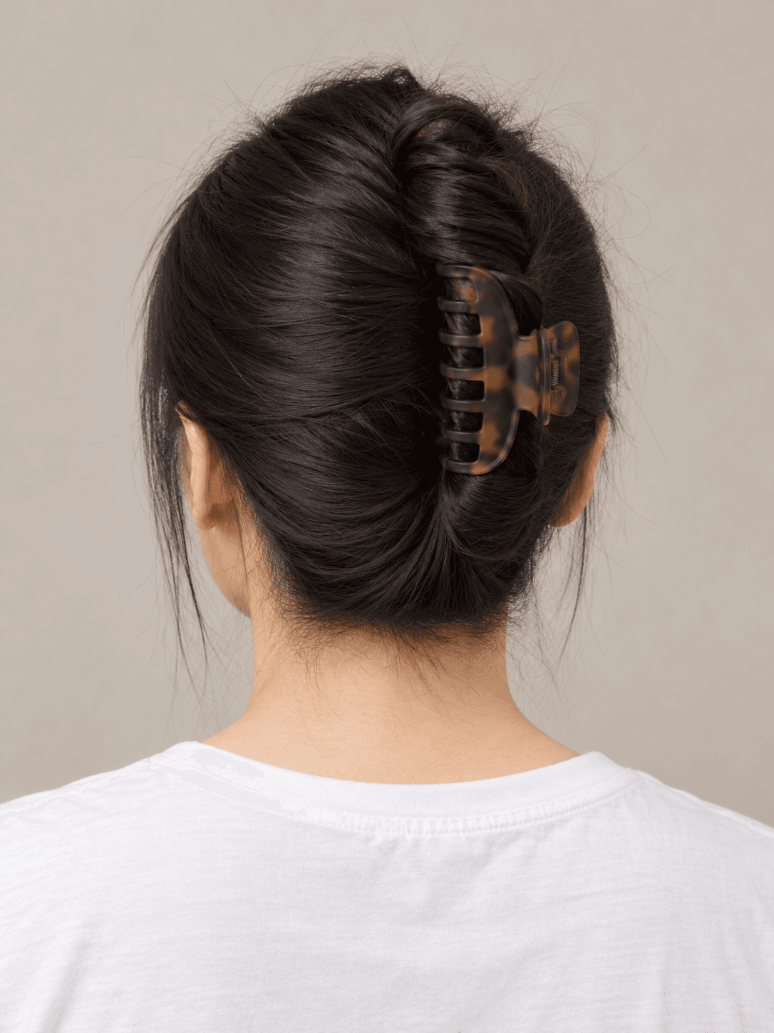 Claw-clip twist on a woman with light skin and straight black hair, back view