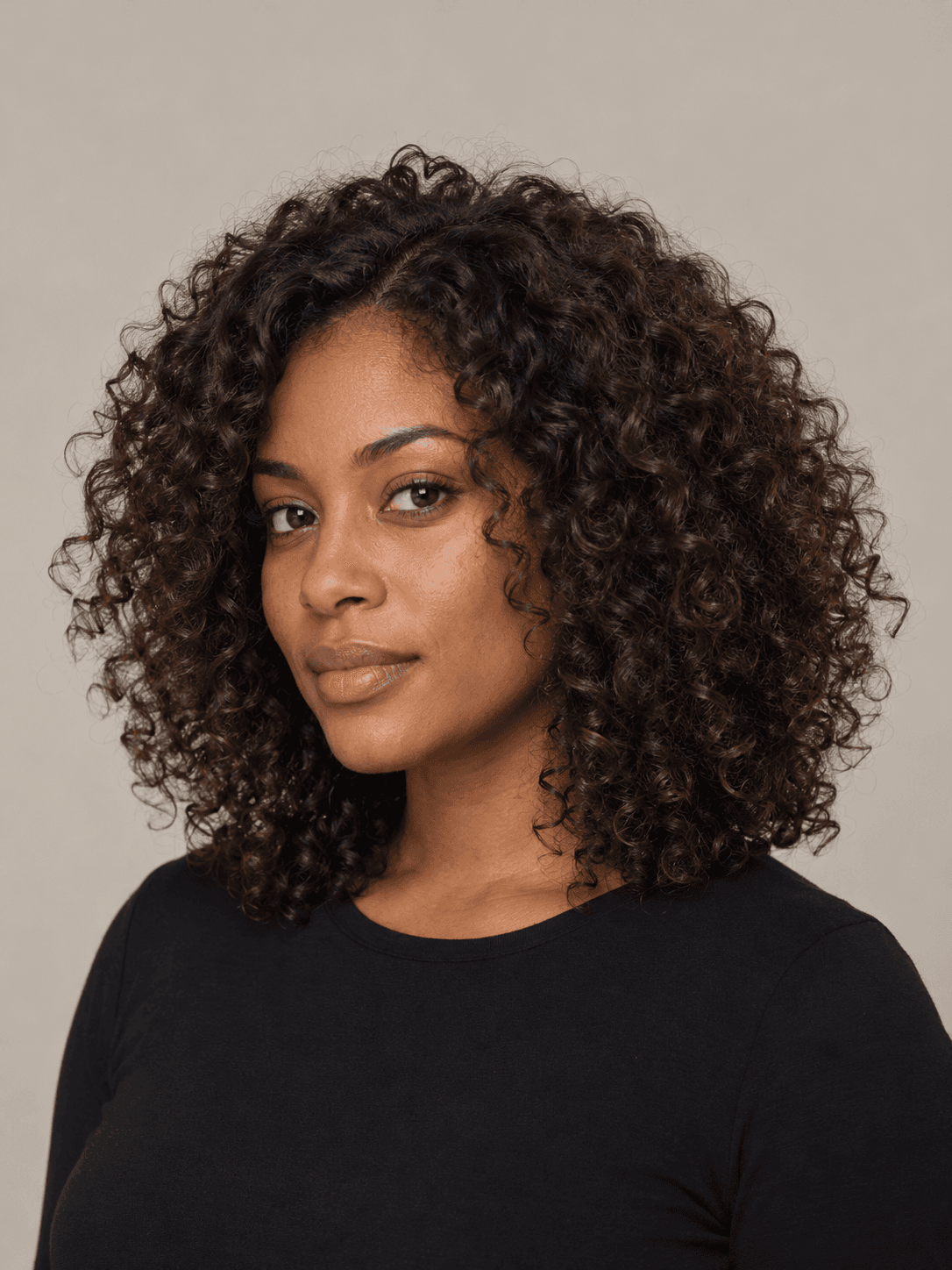 Curly layers hairstyle on a woman with dark brown curly hair, three-quarter view