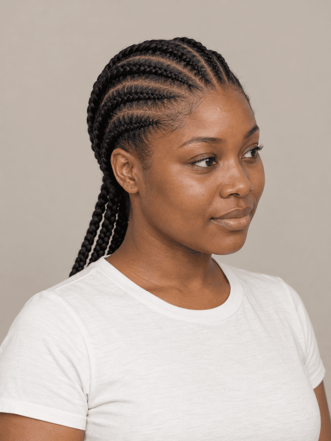 Feed-in Cornrows on a woman with dark brown skin and black hair, three-quarter view