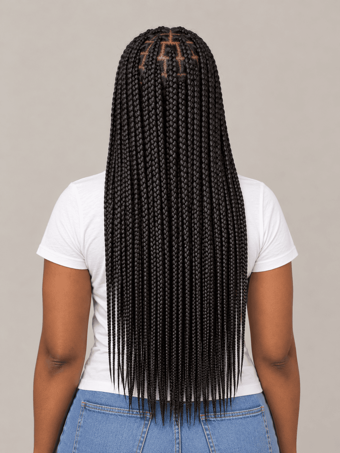 Knotless box braids on a woman with deep brown skin, back view