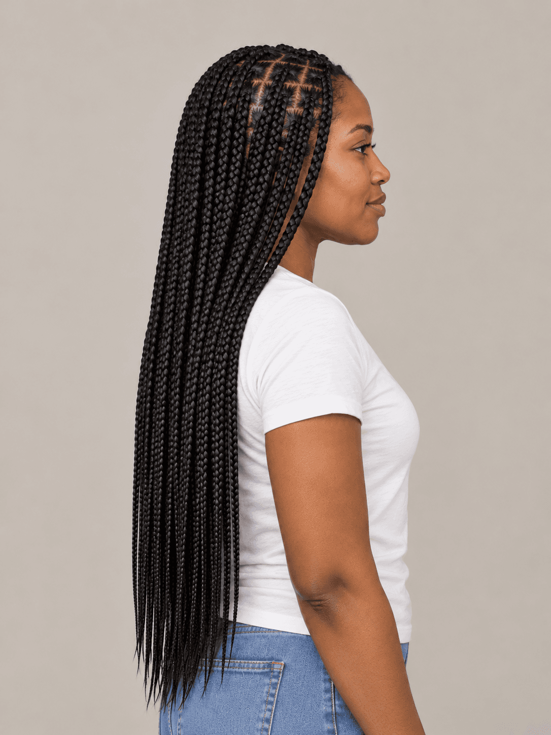 Knotless box braids on a woman with deep brown skin, side view