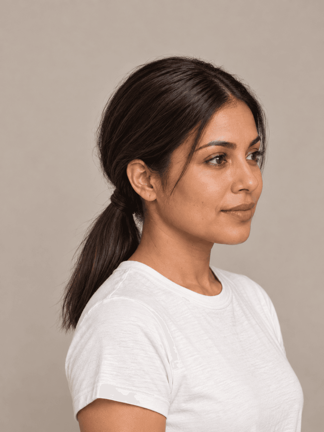 Low Ponytail with Wrapped Base on a woman with light brown skin and dark brown hair, three-quarter view