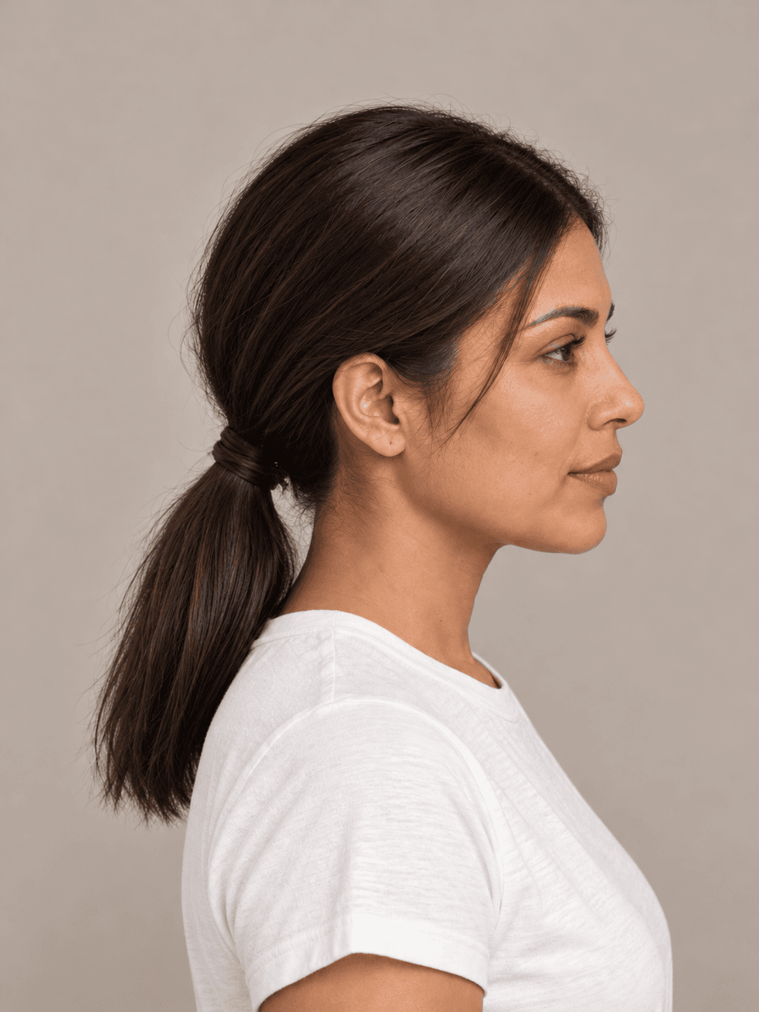 Low Ponytail with Wrapped Base on a woman with light brown skin and dark brown hair, side view