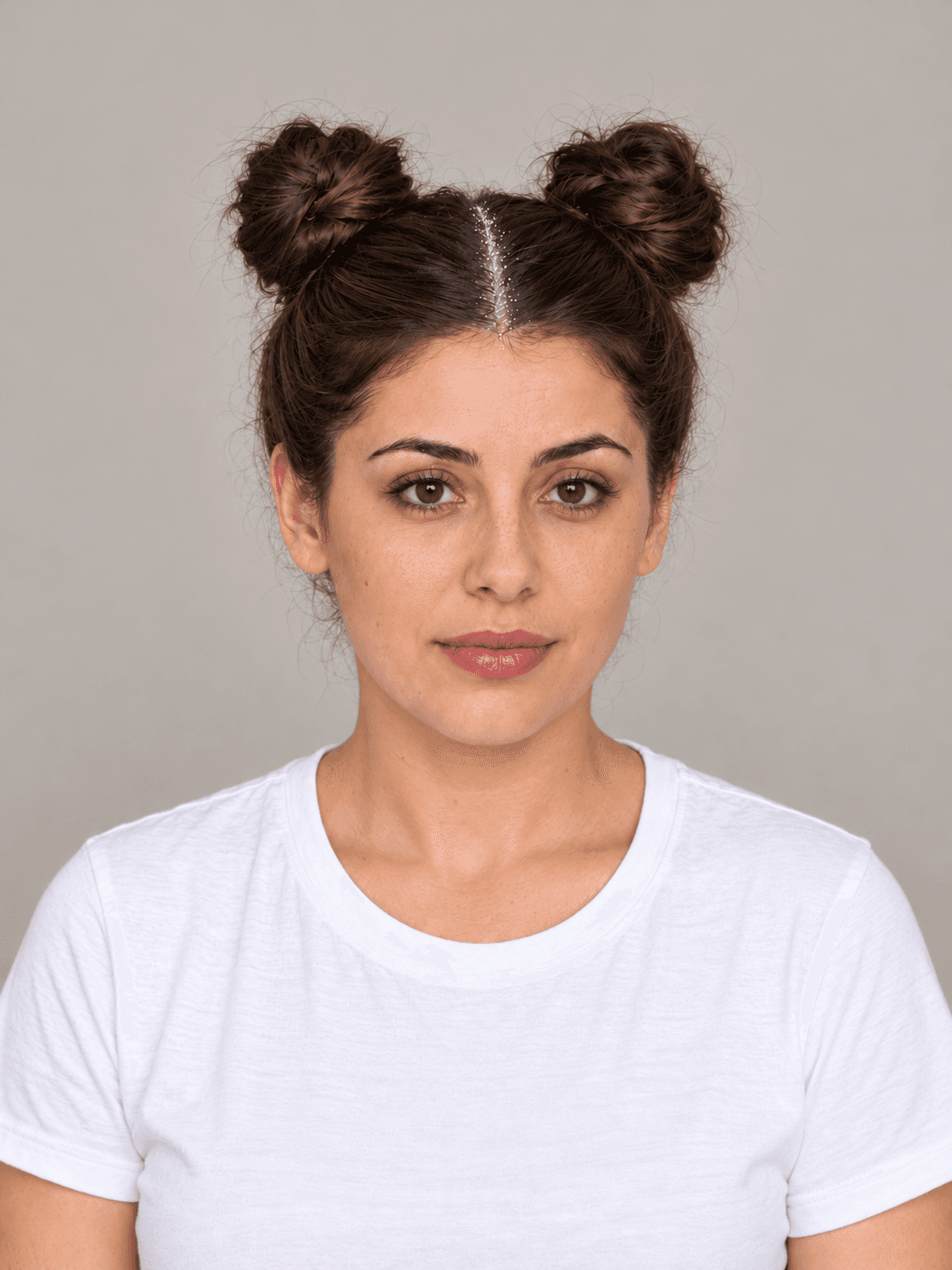 Space Buns with Glitter Roots on a woman with light olive skin and dark brown hair, front view