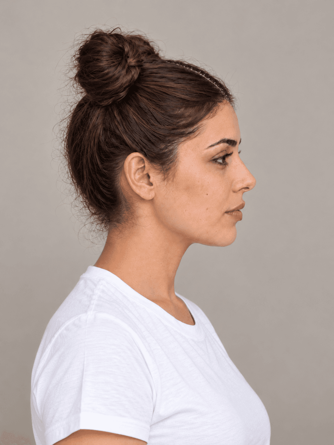 Space Buns with Glitter Roots on a woman with light olive skin and dark brown hair, side view
