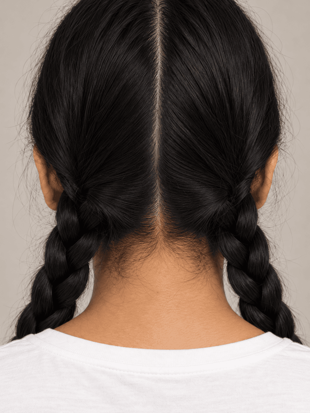 Wednesday Addams Braids on a woman with light brown skin and straight black hair, close view from the back of the centre part and the tops of both braids