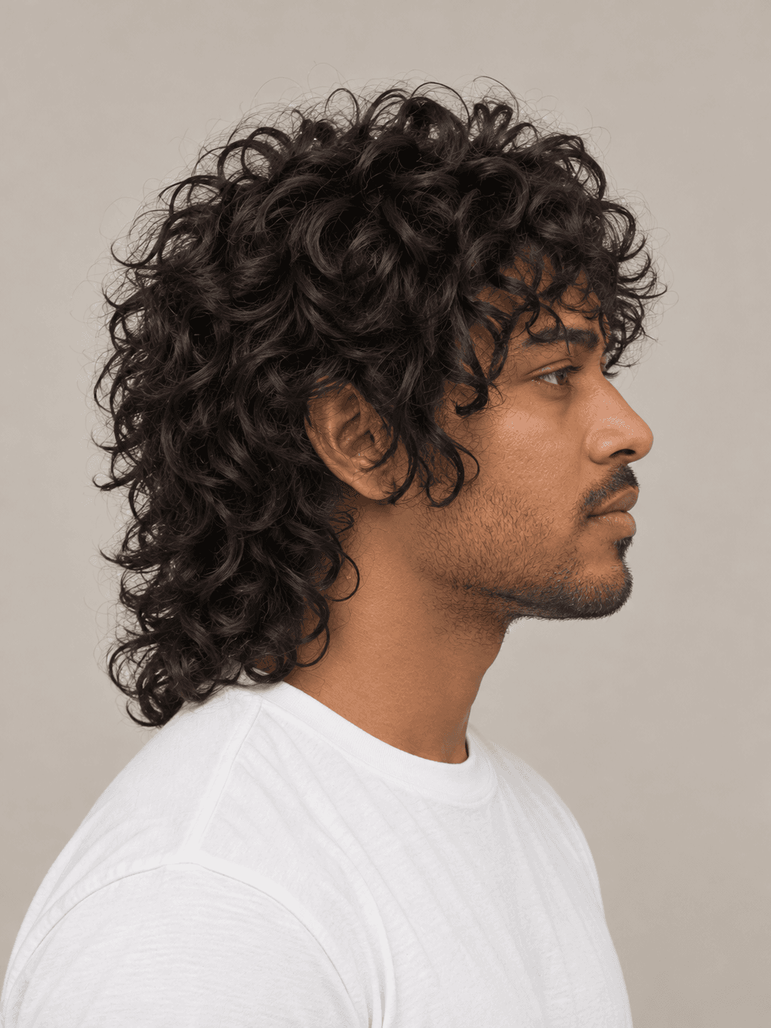 Wolf cut hairstyle on a man with dark curly hair, side view from the other side