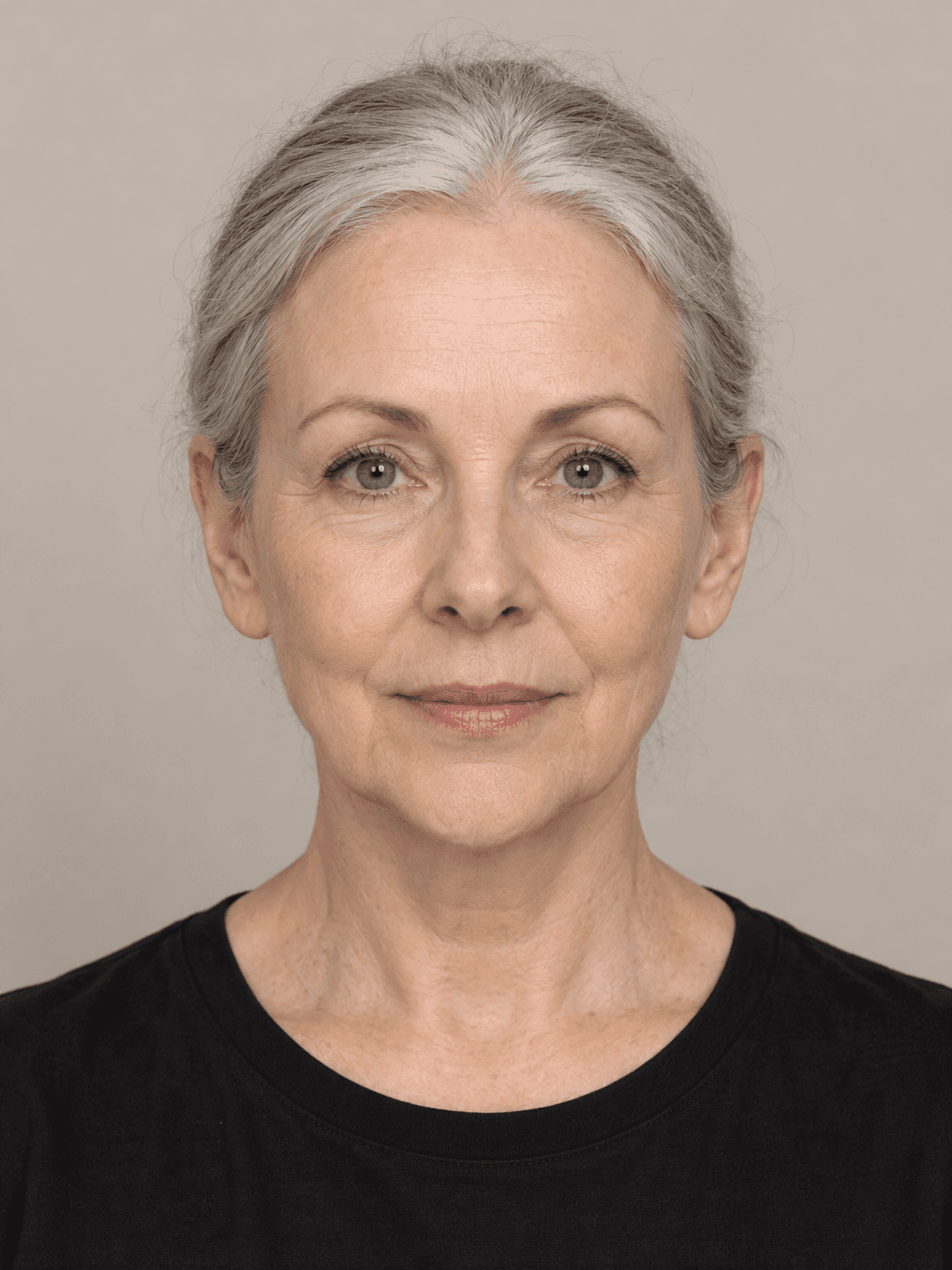 Woman, front view, with fair skin and straight grey hair pulled back in a low bun.