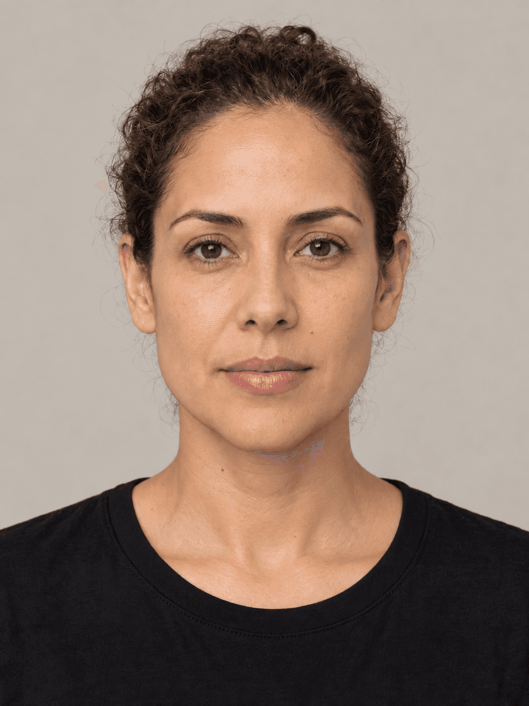 Woman, front view, with medium warm-toned skin and curly brown hair pulled back in a low bun.