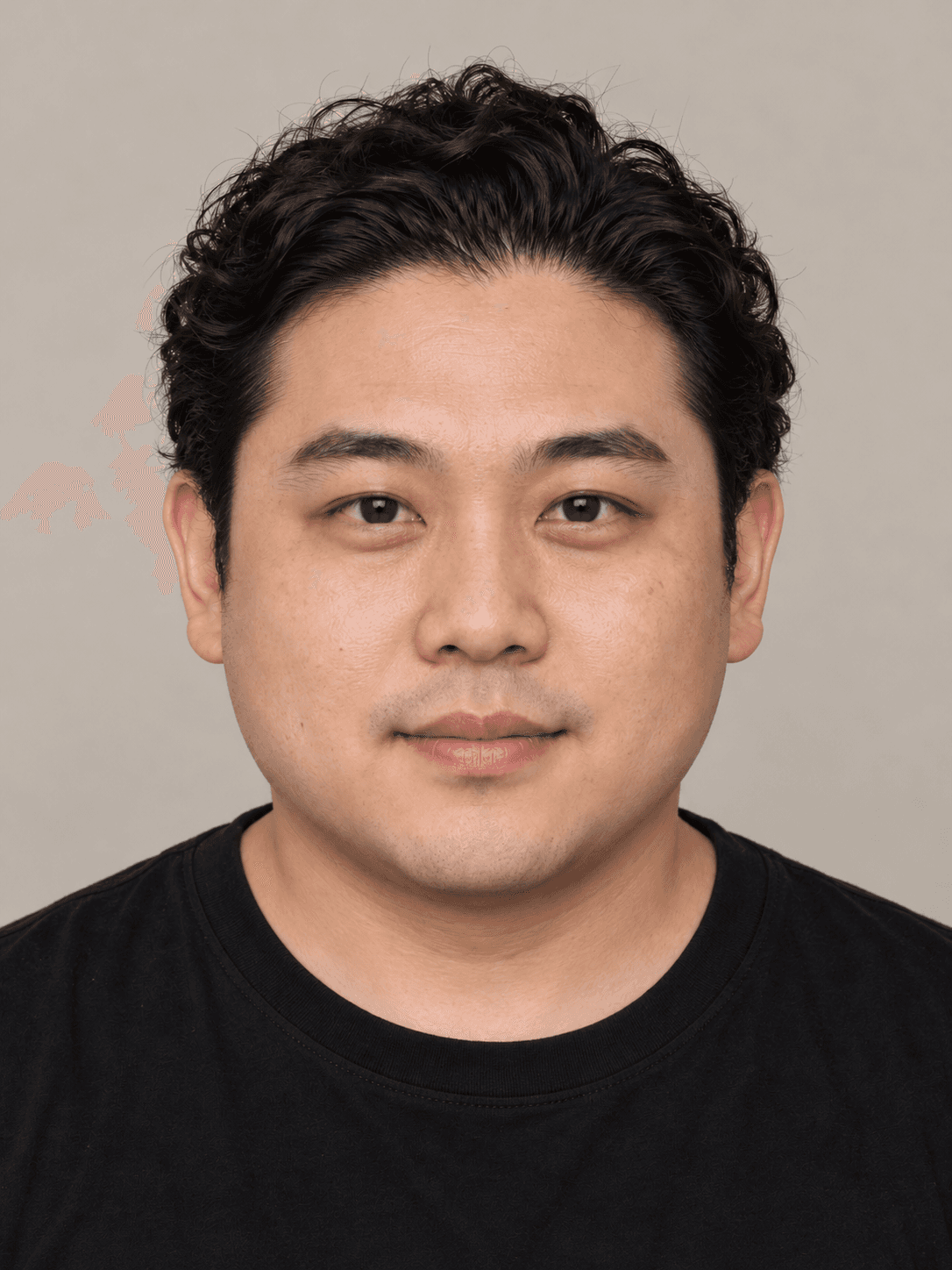 Man, front view, with light medium-toned skin and wavy black hair brushed straight back.
