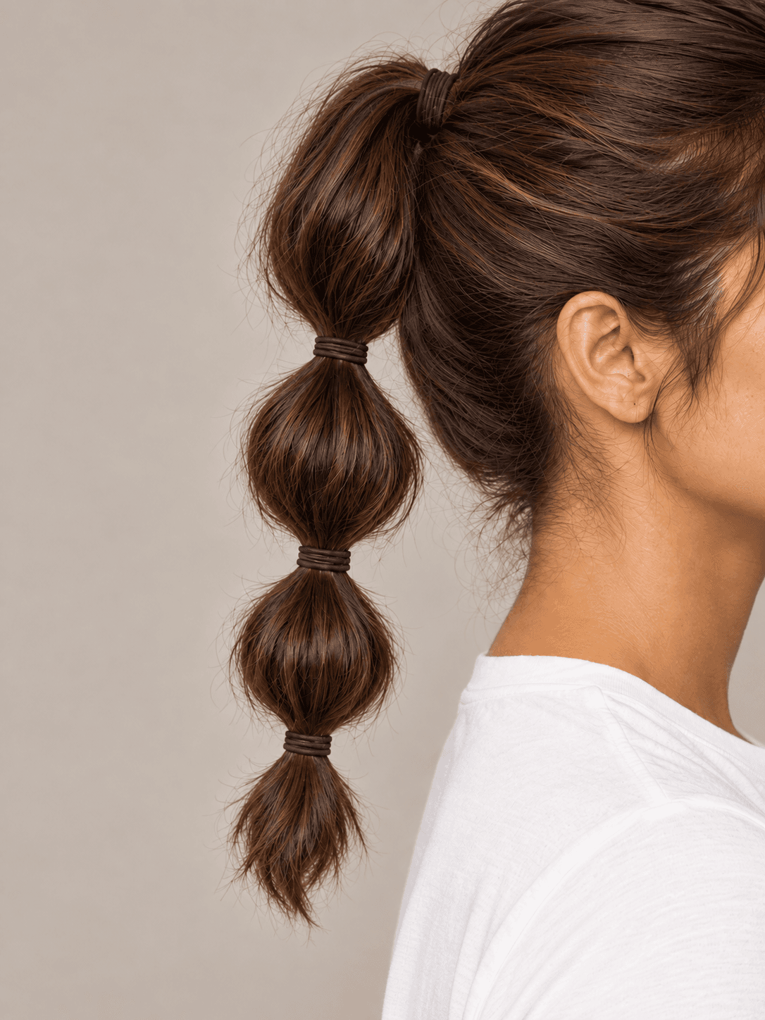 Bubble Ponytail on a woman with light olive skin and brown hair, close side view of the bubbles and the bands between them