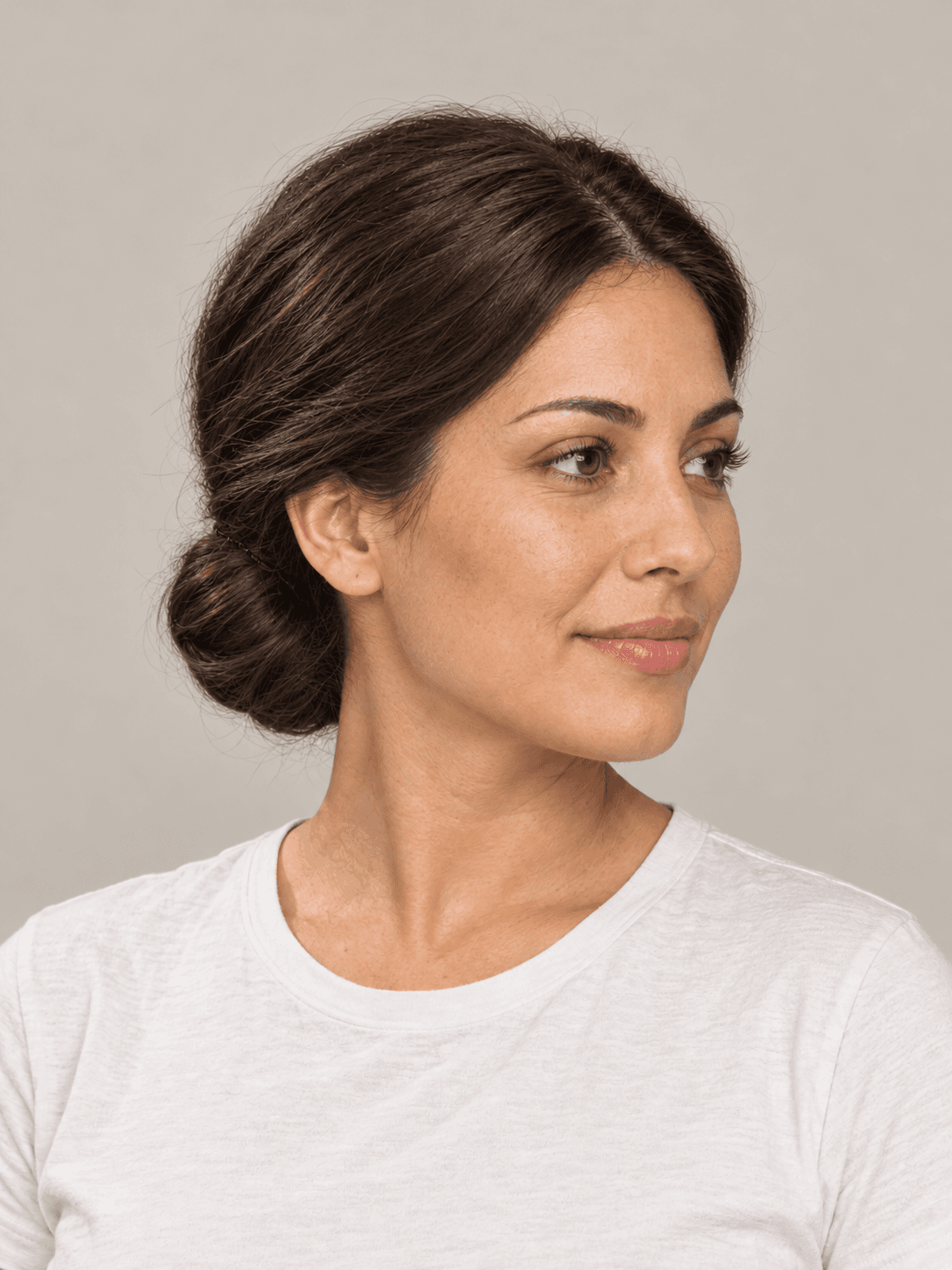 Low Chignon on a woman with light olive skin and dark brown hair, three-quarter view