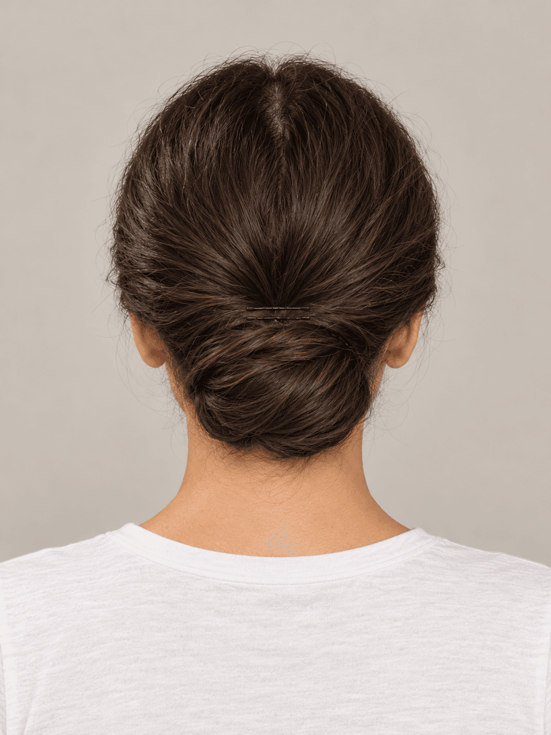 Low Chignon on a woman with light olive skin and dark brown hair, back view